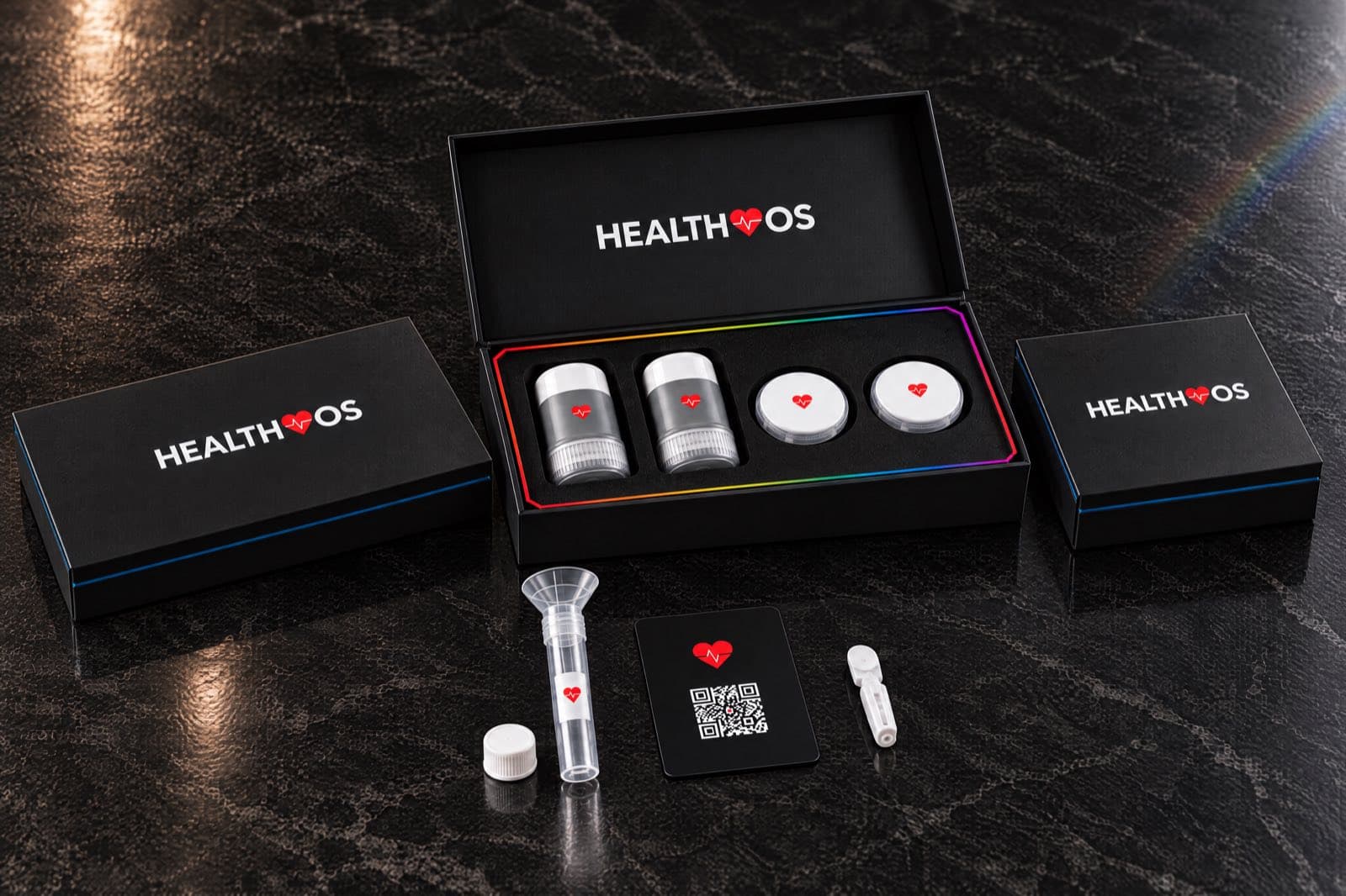 Three black HealthOS boxes side by side on dark marble: the DNA kit, the open glucose sensor box and the blood home kit, with a saliva tube, a QR card and a lancet in front