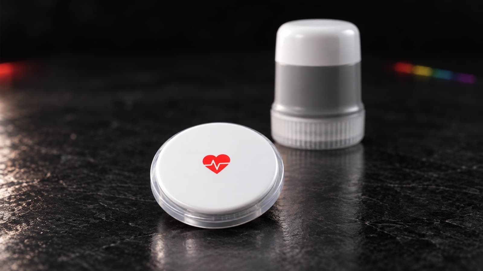 The HealthOS Sensor, a small white disc, with its applicator